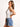 Model is wearing a white sleeveless surplice bodysuit.
