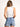 Model is wearing a white sleeveless surplice bodysuit.