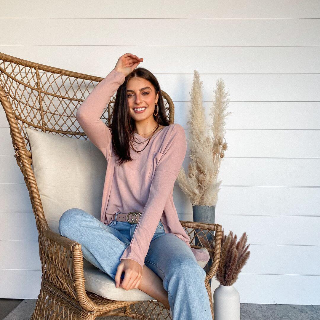 woman in a sweater and jeans sitting in a chair
