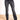 Model is wearing washed black flare leg jeans with raw cut hem and front button and zipper closure