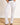 Model is wearing white denim flare jeans with raw cut hem.  Front button and zipper closure and 5 pockets 