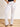 Model is wearing white denim flare jeans with raw cut hem.  Front button and zipper closure and 5 pockets 