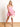 Model is wearing a pink cutout romper.