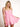 Model is wearing a pink cutout romper.
