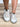 Model is wearing white/gold metallic star sneakers.