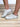 Model is wearing white/gold metallic star sneakers.