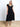 Model is wearing a black ruffle hem midi dress.