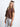 Model is wearing a brown cable knit sweater vest.