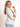 Model is wearing a bone colored scrunch sleeve blazer.