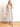 Model is wearing a cream linen midi dress with black piping.