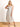 Model is wearing a cream linen midi dress with black piping.